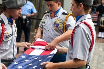 Members of the Frankford High School ROTC Program fold a flag to honor fallen police and firefighters on September 11, 2016. (Brad Larrison for NewsWorks)