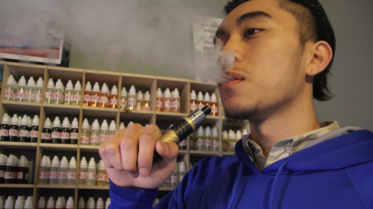 Sophran Sok demonstrates the use of an electronic vaping device at Exclusive Vape Shop on South Street. New federal rules regarding e-cigarettes will have a distinct effect in Pennsylvania. (Emma Lee/for NewsWorks)