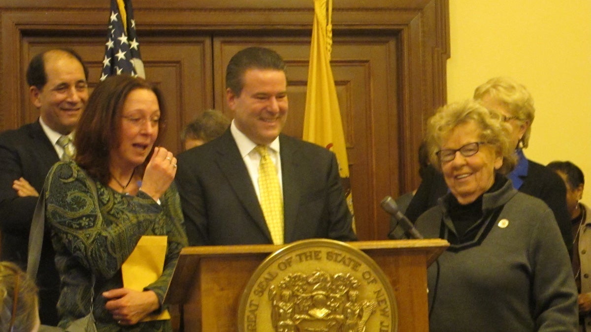 Adoptees Theresa Carroll (seond from left)and Gary Brozowski (at podium) get their birth records at a ceremony at the New Jersey Statehouse in Trenton Monday. (Phil Gregory/WHYY)