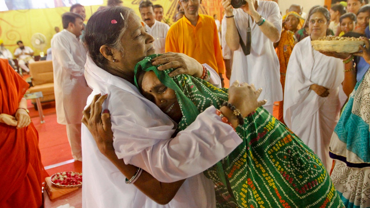  Indian spiritual leader, Mata Amritanandamayi, hugs a devotee during a function in Ahmadabad, India. Known among her followers as 