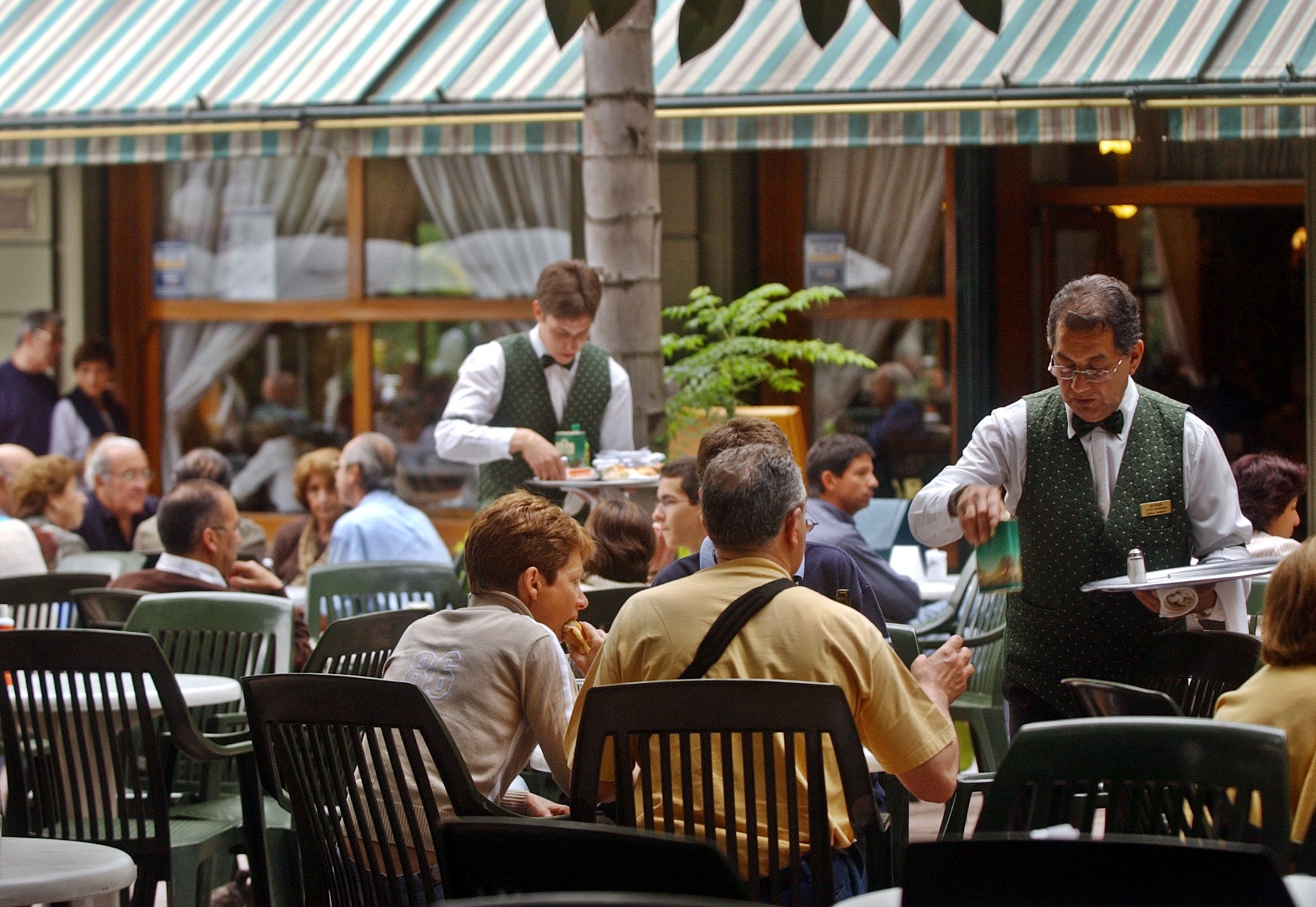 Waiters serve patrons dining in an outdoor cafe in one of Buenos Aires' swanky neighborhoods, Recoleta. Although malnutrition is rampant in the heartland and in the vast rustbelt ringing Buenos Aires, the good life goes on for part of Argentine society. (AP file Photo/Natacha Pisarenko) 