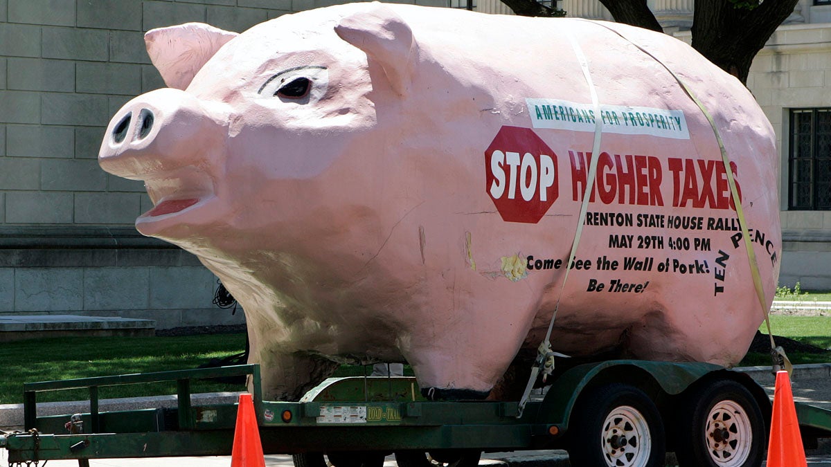  A pig parked next to the New Jersey Statehouse in Trenton expresses the sentiments of taxpayers in 2008 -- which has not changed since then. State officials say merging municipal services could help keep costs down.(AP file photo) 