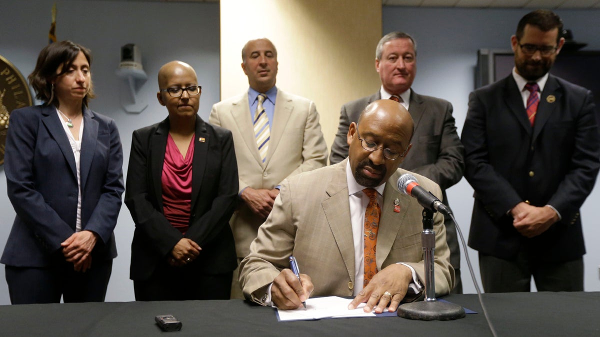  Mayor Michael Nutter signs legislation that broadened equality protections for lesbian, gay, bisexual, and transgender people living and working in the city. Gloria Casarez, second from left, was among those looking on at the 2013 signing. Casarez died Sunday of cancer.(AP file photo) 