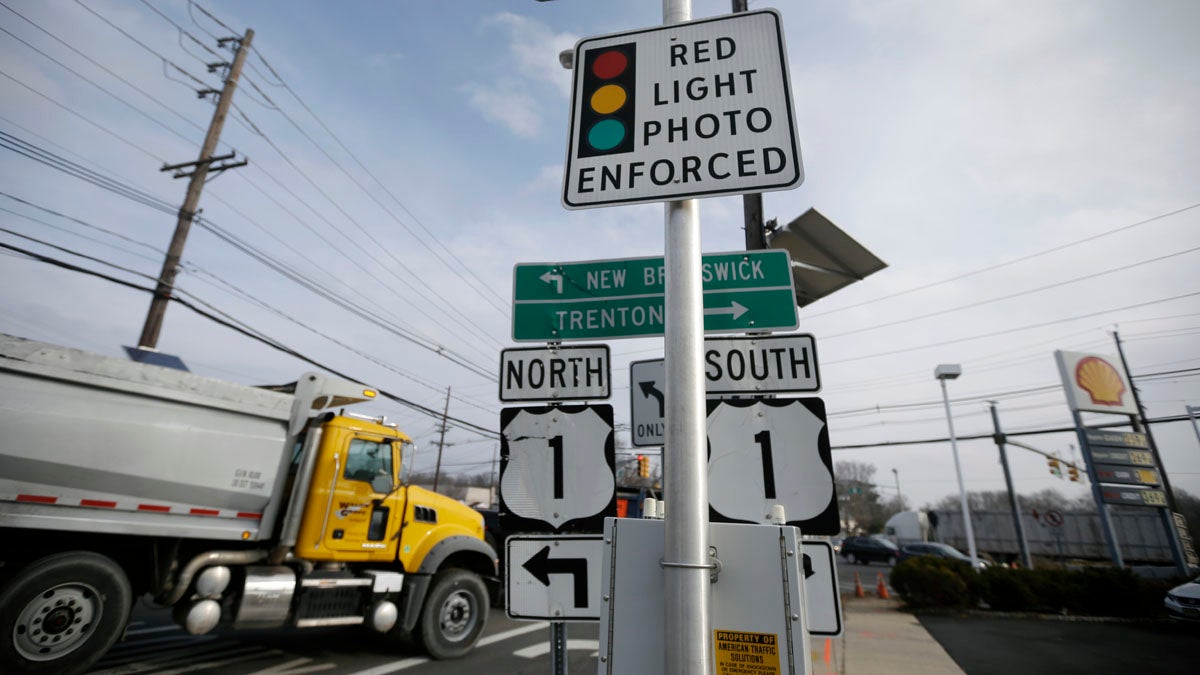  A truck passes a photo enforcement sign that is placed below a red-light camera at the intersection of Route 1 and Franklin Corner Road Tuesday in Lawrence. By midnight, Tuesday, cameras that have recorded hundreds of thousands of red-light violations in two dozen towns are scheduled to go dark as the much-scrutinized pilot program comes to an end after five years filled with controversy. (AP Photo/Mel Evans) 