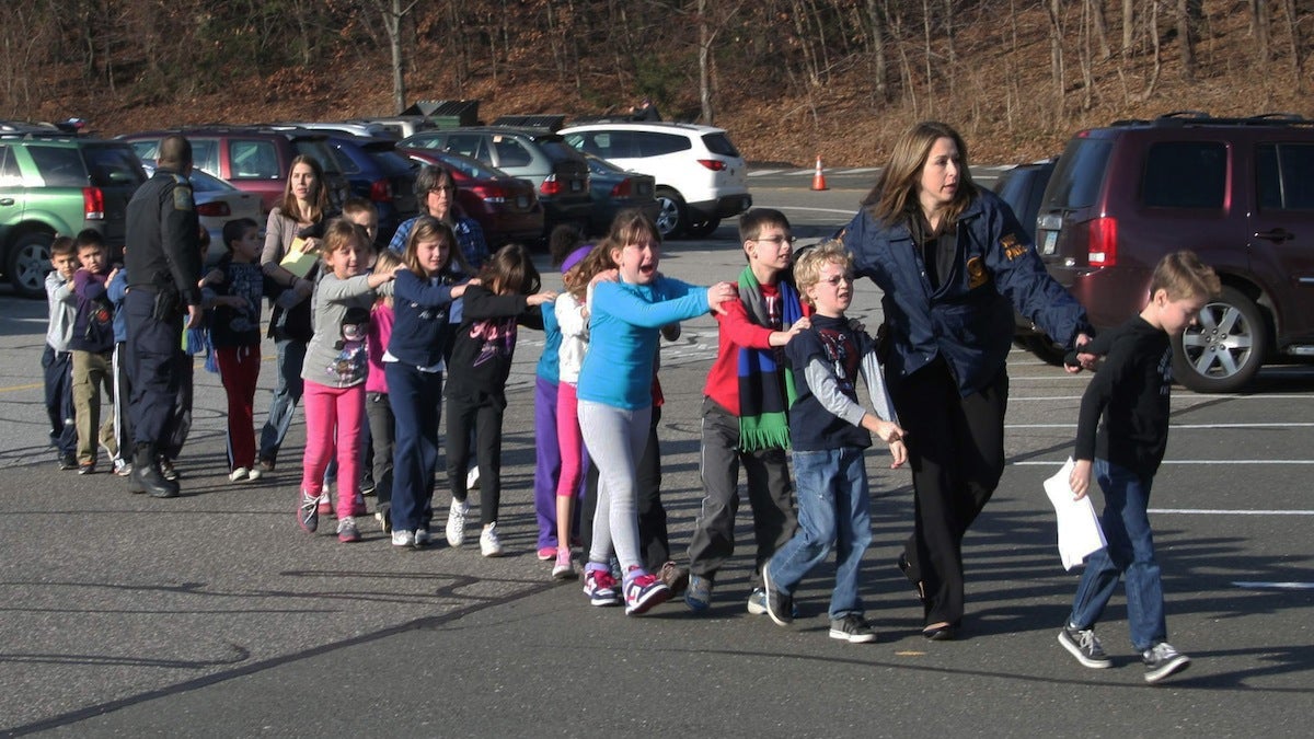  In this photo provided by the Newtown Bee, Connecticut State Police lead a line of children from the Sandy Hook Elementary School in Newtown, Conn. on Friday, Dec. 14, 2012 after a shooting at the school. Hundreds of children at the school that day survived, but the horrors have been especially difficult to overcome for some of the 6- and 7-year-olds who witnessed the bloodbath, even as the school year resumed in autumn of 2013. (AP Photo/Newtown Bee, Shannon Hicks, file) 