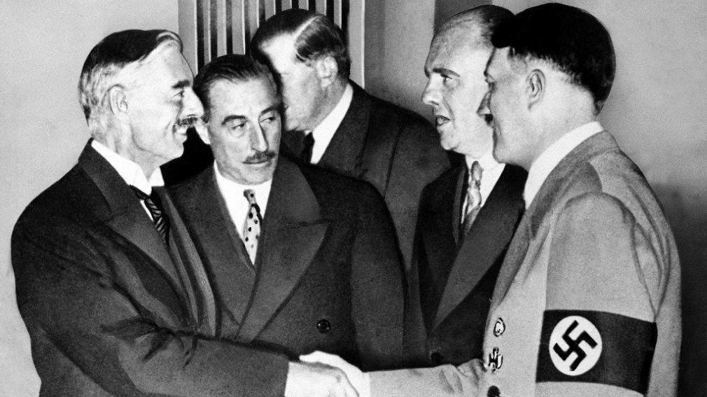  Hands clasped in friendship, Adolf Hitler and England's Prime Minister Neville Chamberlain, are shown in this historic pose at Munich on Sept. 30, 1938. This was the day when the premier of France and England signed the Munich agreement, sealing the fate of Czechoslovakia. Next to Chamberlain is Sir Neville Henderson, British Ambassador to Germany. Paul Schmidt, an interpreter, stands next to Hitler. (AP Photo) 