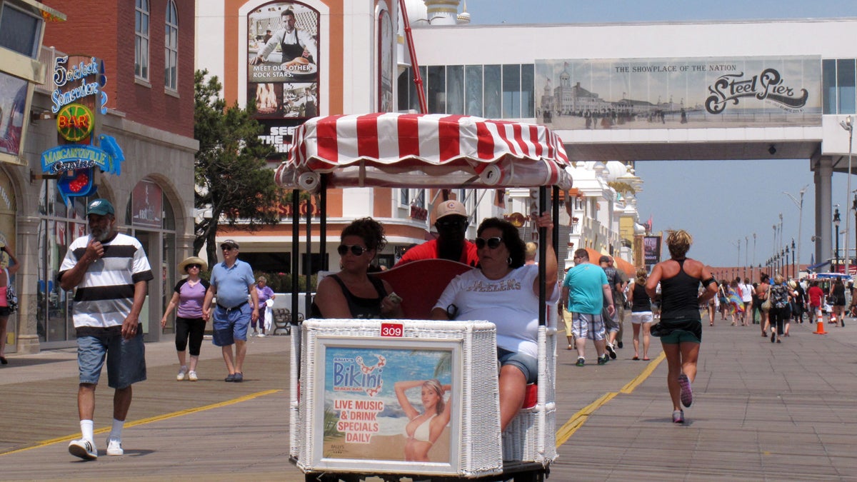 Tourists ride in a rolling chair on the Atlantic City Boardwalk. Hoping to draw visitors during October