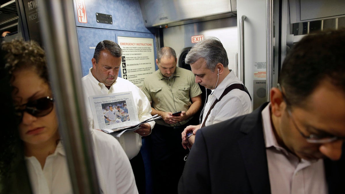  Commuters read and check their phones as they stand on a New Jersey Transit passenger train to New York. (AP Photo/Mel Evans) 