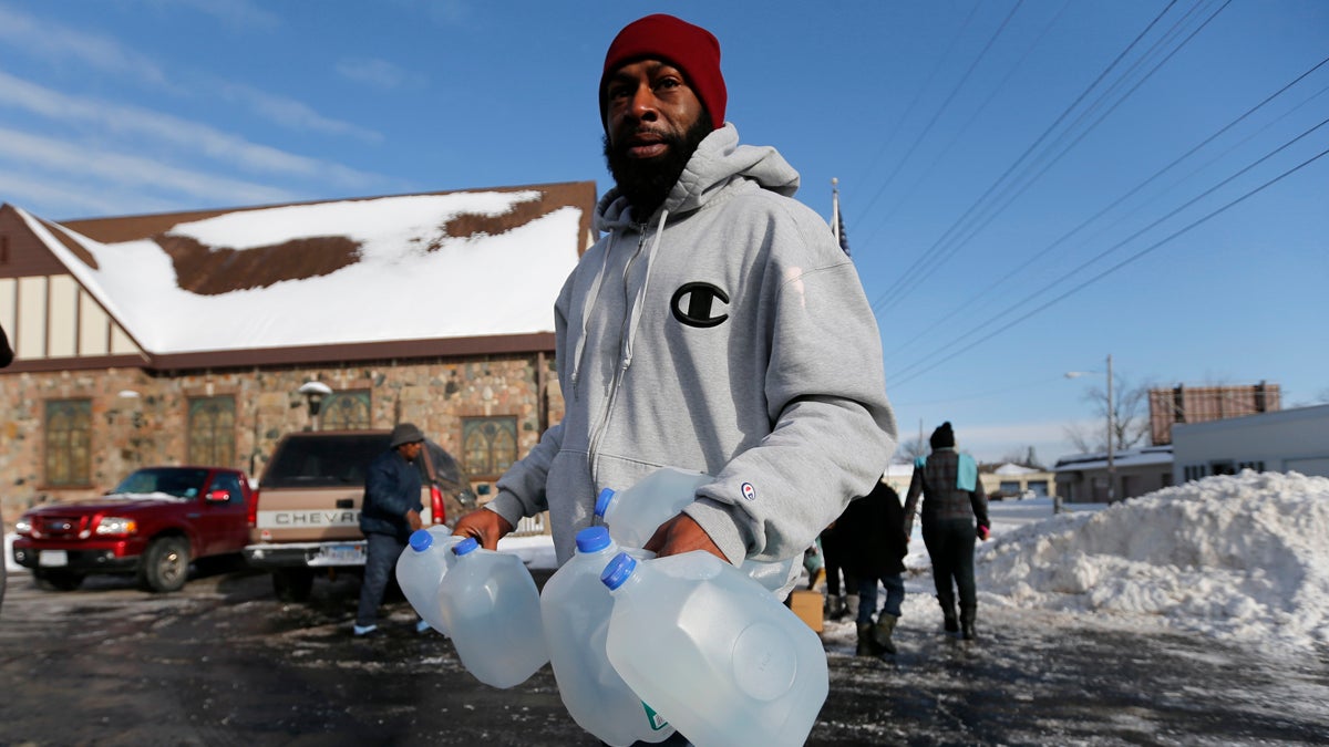 Lemott Thomas carries free water being distributed at the Lincoln Park United Methodist Church in Flint