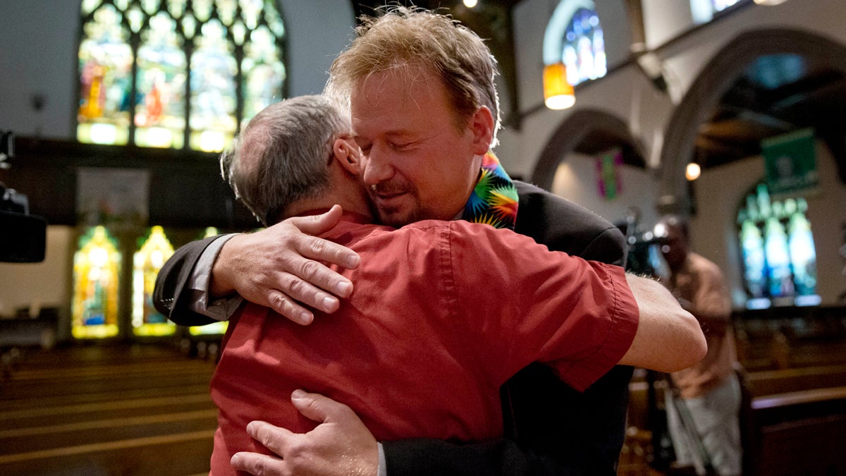  United Methodist pastor Frank Schaefer, right, hugs the Rev. David Wesley Brown Tuesday at First United Methodist Church of Germantown in Philadelphia. Schaefer, who presided over his son's same-sex wedding ceremony and vowed to perform other gay marriages if asked, can return to the pulpit after a United Methodist Church appeals panel  overturned a decision to defrock him. (AP Photo/Matt Rourke) 