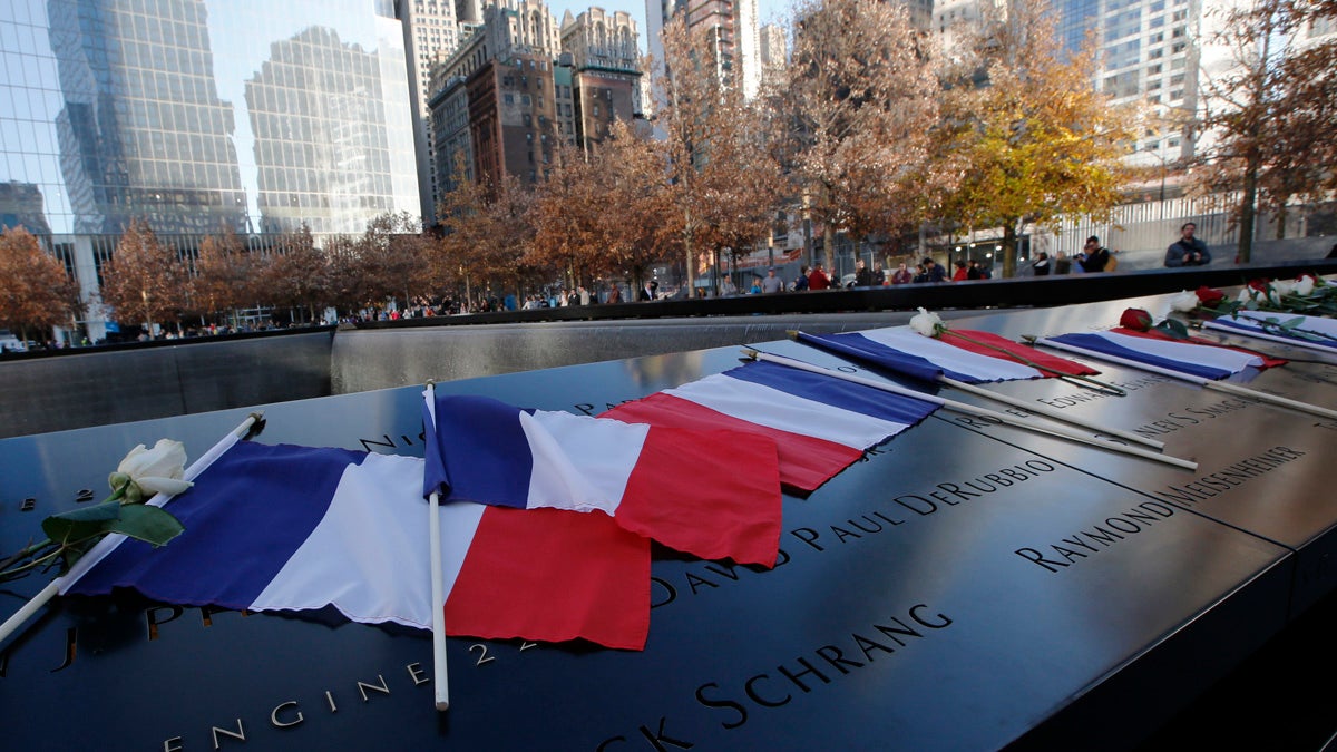 French flags rest on the engraved names at the 9/11 Memorial South Pool rim at the National September 11 Memorial and Museum following a tribute to victims of the  Paris terrorist attacks. (Kathy Willens/AP)