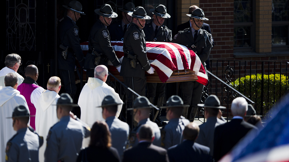 The flag-draped casket of 26-year-old State Trooper David Kedra is taken from Christ the King Church in Philadelphia Monday. (AP photo/Matt Rourke)