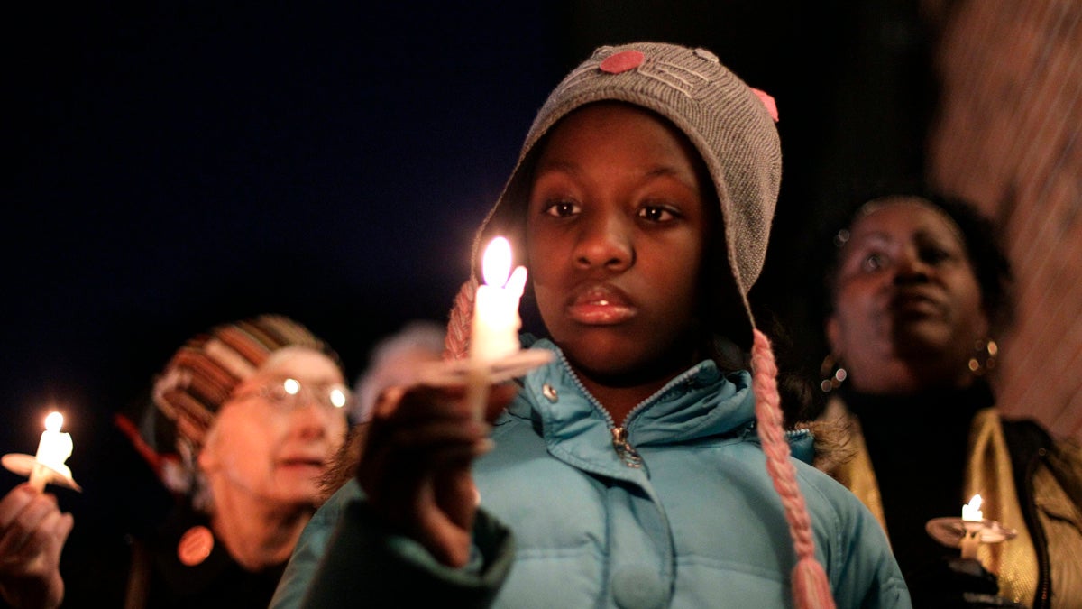  In January of 2012, Courtney Thornton looks at her candle during a vigil outside the Chester Upland School District administration building in Chester, Pennsylvania. More than two decades after being declared financially distressed, the long-struggling district may not be able to open its doors this school year with a 