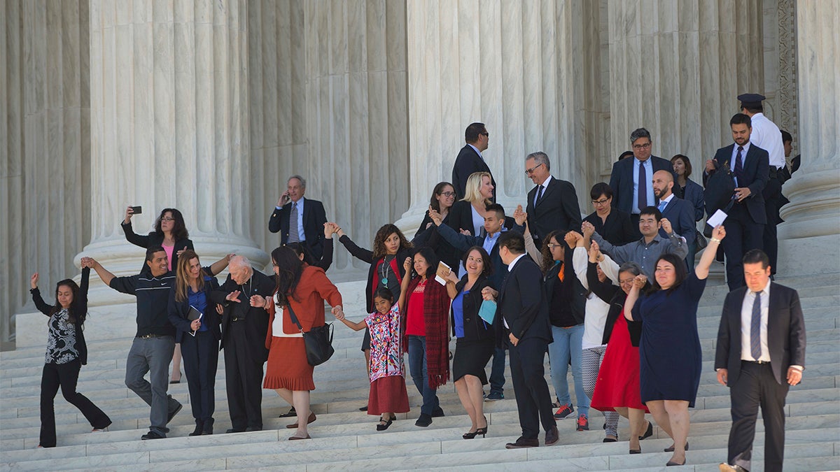 Supporters of  immigration reform hold hands as they leave together after hearing arguments at the Supreme Court in the case U.S. versus Texas Monday in Washington. (AP Photo/Pablo Martinez Monsivais)