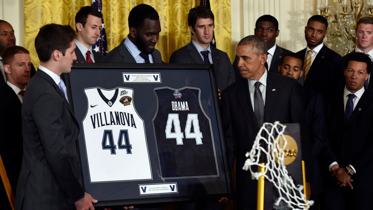 President Barack Obama receives a gift from NCAA Champion Villanova Wildcats men's basketball team members Ryan Arcidiacono