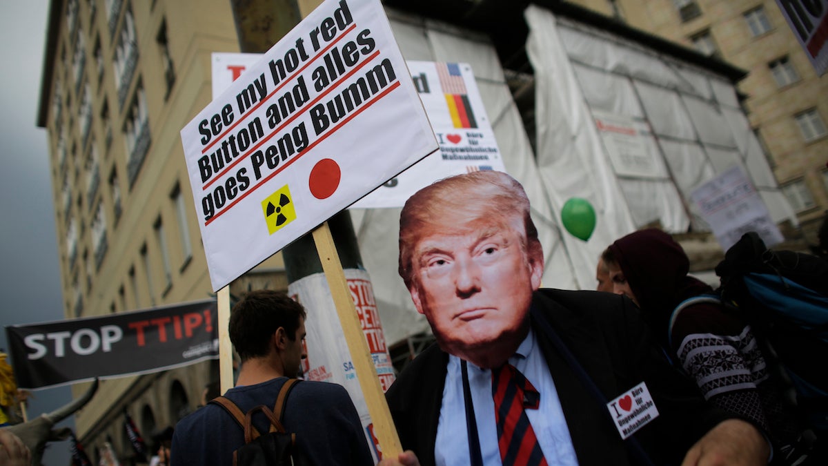 A man with a mask of United States Republican presidential candidate Donald Trump attends a demonstration against the planned Transatlantic Trade and Investment Partnership