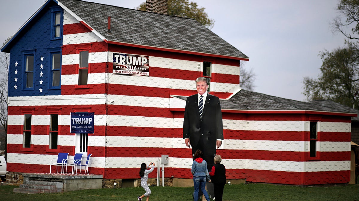 A young visitor takes a photo of a giant photo of  Donald Trump in Youngstown