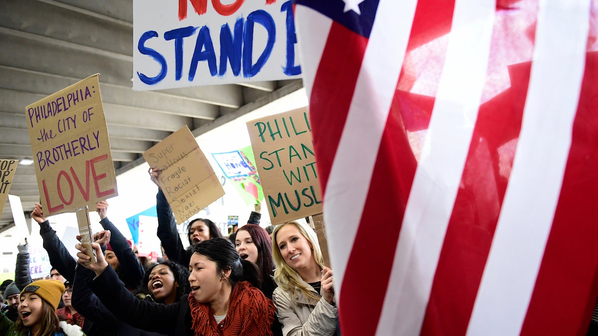 Demonstrators hold signs during a protest against President Donald Trump's executive order banning travel to the U.S. by citizens of Iraq