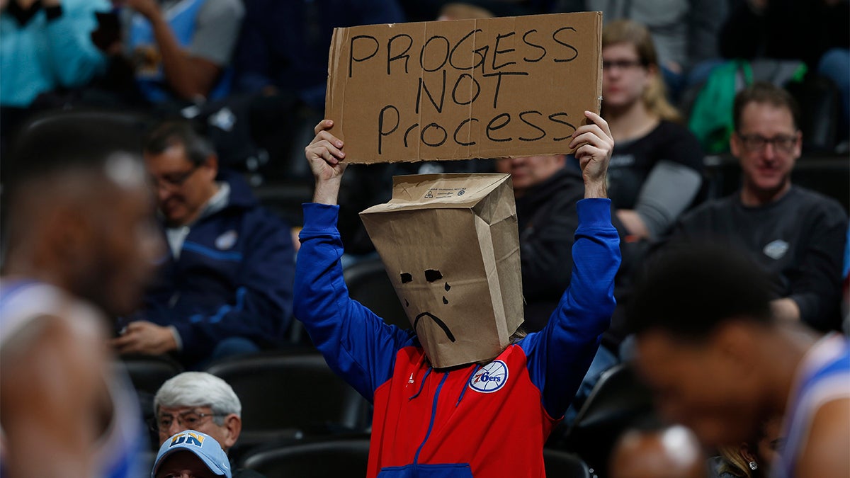 A Philadelphia 76ers fan wears a bag over his head and holds up a placard while watching his team face the Denver Nuggets in the first half of an NBA basketball game Wednesday