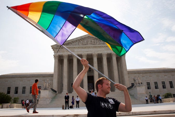  John Becker, 30, of Silver Spring, Md., waves a rainbow flag in support of gay marriage outside of the Supreme Court in Washington. (AP Photo/Jacquelyn Martin) 