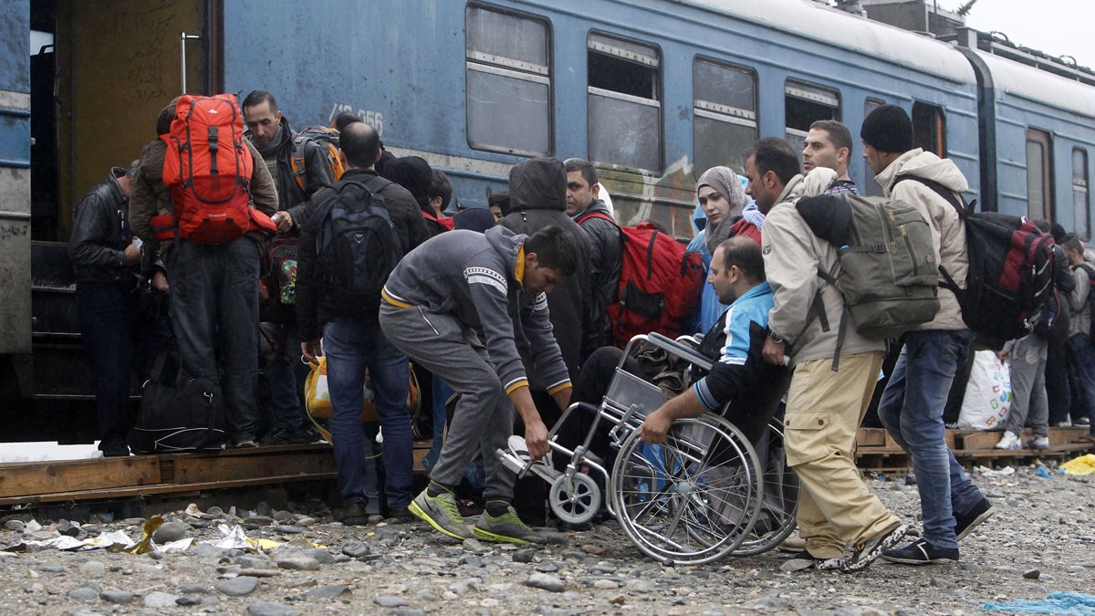  People help a wheelchair user board a train with others, heading toward Serbia, at the transit camp for refugees near the southern Macedonian town of Gevgelija early this month. Several thousand migrants and refugees enter daily from Greece into Macedonia on their way through the Balkans toward the more prosperous European Union countries. More than 500,000 people have arrived this year in EU seeking sanctuary or jobs, sparking the EU's biggest refugee emergency in decades. (Boris Grdanoski/AP Photo) 