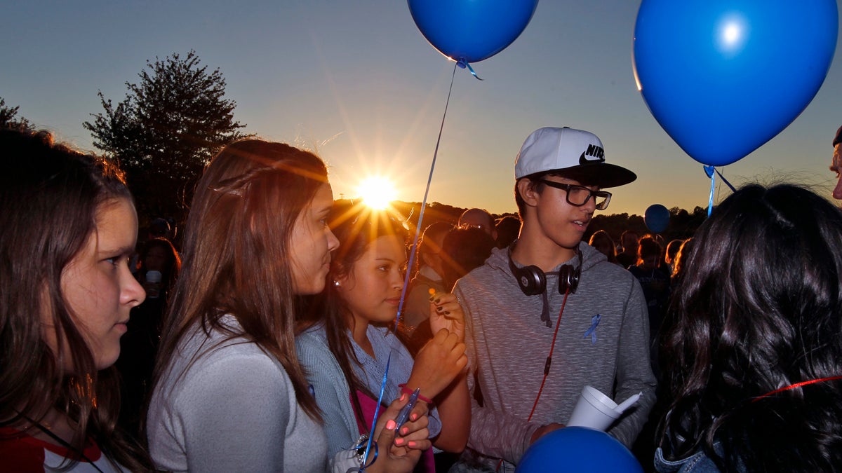  Students hold candles and balloons as they join hundreds of people gathering in the setting sun, for an anti-bullying rally Sunday, Oct. 12, 2014, in Sayreville, N.J. Organizers say the goal of the event is to promote unity and healing within the community, as well as to show support for the victims of bullying. (Mel Evans/AP Photo) 