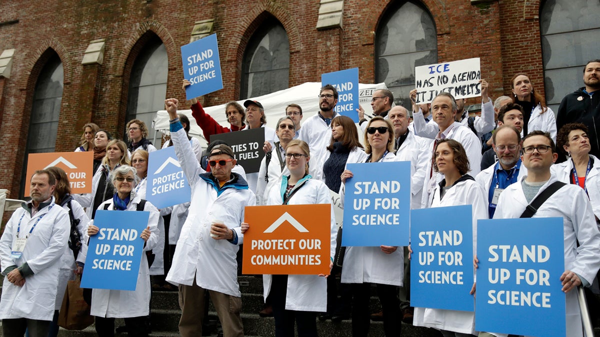 Scientists hold signs during a rally in conjunction with the American Geophysical Union's fall meeting Tuesday