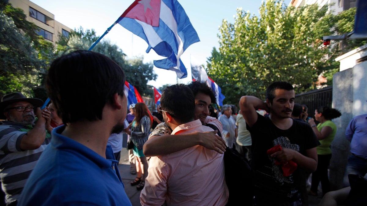  People embrace while celebrating the restoration of diplomatic relations between Cuba and the United States, outside of the Cuban Embassy in Santiago, Chile, Wednesday Dec. 17, 2014. After a half-century of Cold War acrimony, the United States and Cuba abruptly moved on Wednesday to restore diplomatic relations between the two nations. U.S. President Barack Obama spoke as Cuban President Raul Castro was addressing his nation in Havana, where church bells rang and school teachers paused lessons to mark the news. (Luis Hidalgo/AP Photo) 