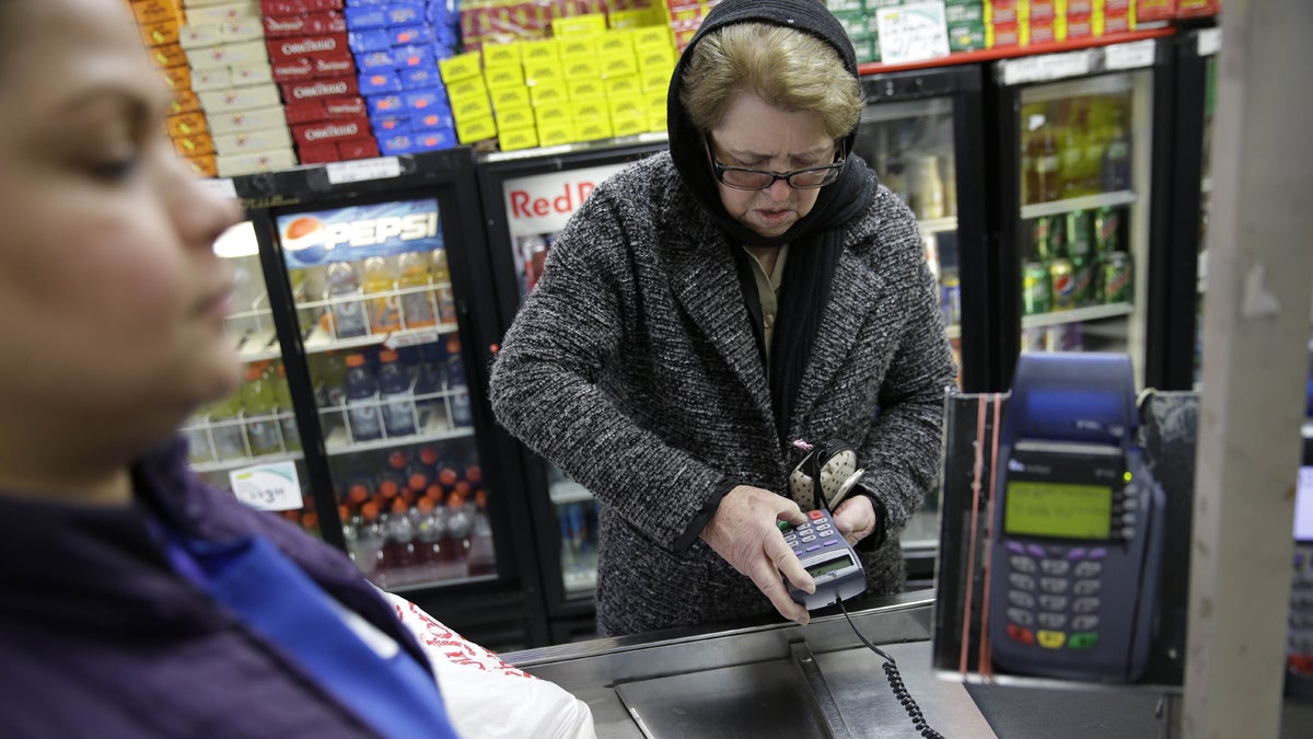 A woman pays for her groceries using a food stamp program at a supermarket  (Seth Wenig/AP Photo)