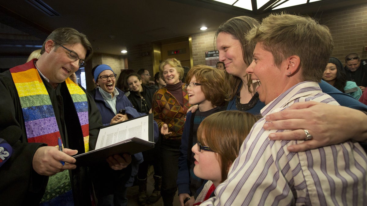  Ruth Hackford-Peer, right, and Kim Hackford-Peer, standing next to her, are married by Rev. Curtis Price, left, while hugging their two children Riley Hackford-Peer, back middle, and Casey Hackford-Peer, bottom middle, in the lobby of the Salt Lake County Clerk's Office in Salt Lake City on Friday, Dec. 20, 2013. A federal judge ruled on Friday that Utah's ban on same-sex marriage is unconstitutional. (Kim Raff/AP Photo) 