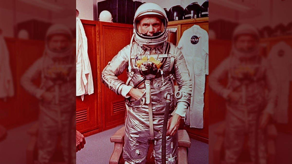 Astronaut John Glenn stands in his space suit