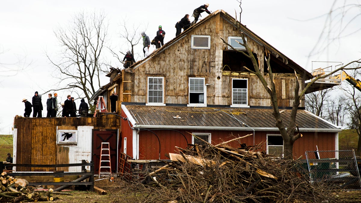 People clean up in the aftermath of a storm with high winds Thursday