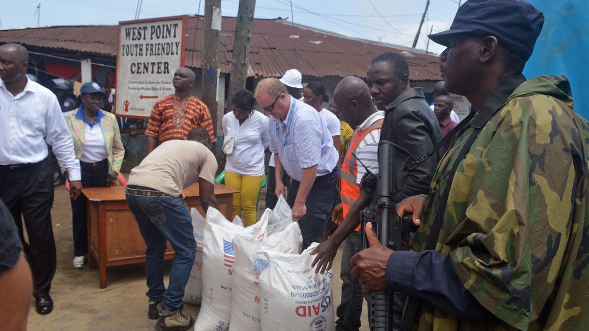  People hand out foodstuff donated by the U.S at the West Point area that has been hard hit by the Ebola virus in Monrovia, Liberia, Tuesday, Aug. 26, 2014. The Ebola virus has the 'upper hand' in an outbreak that has killed more than 1,400 people in West Africa, a top American health official has said, but experts have the tools to stop it. (Abbas Dulleh/AP Photo) 