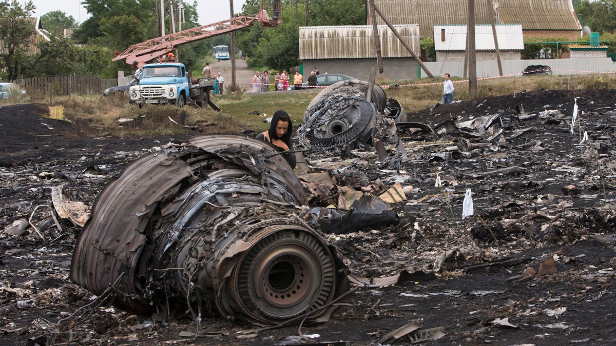  A woman walks at the site of a crashed Malaysia Airlines passenger plane near the village of Rozsypne, eastern Ukraine Friday, July 18, 2014. Rescue workers, policemen and even off-duty coal miners were combing a sprawling area in eastern Ukraine near the Russian border where the Malaysian plane ended up in burning pieces Thursday, killing all 298 aboard. (Dmitry Lovetsky/AP Photo) 