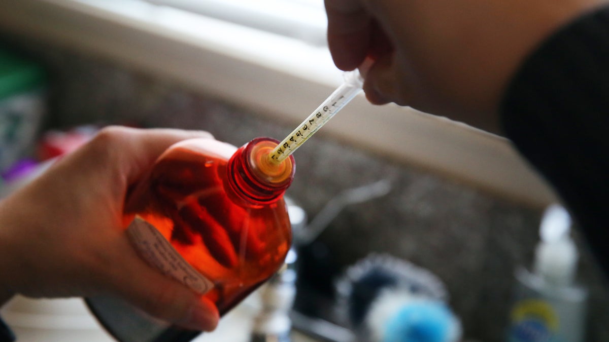  FILE - In this file photo, a woman loads an oral syringe with cannabis-infused oil used to treat her 4-year-old daughter who suffers from severe epilepsy, at their home in Colorado Springs, Colo. (Brennan Linsley/AP Photo, file) 
