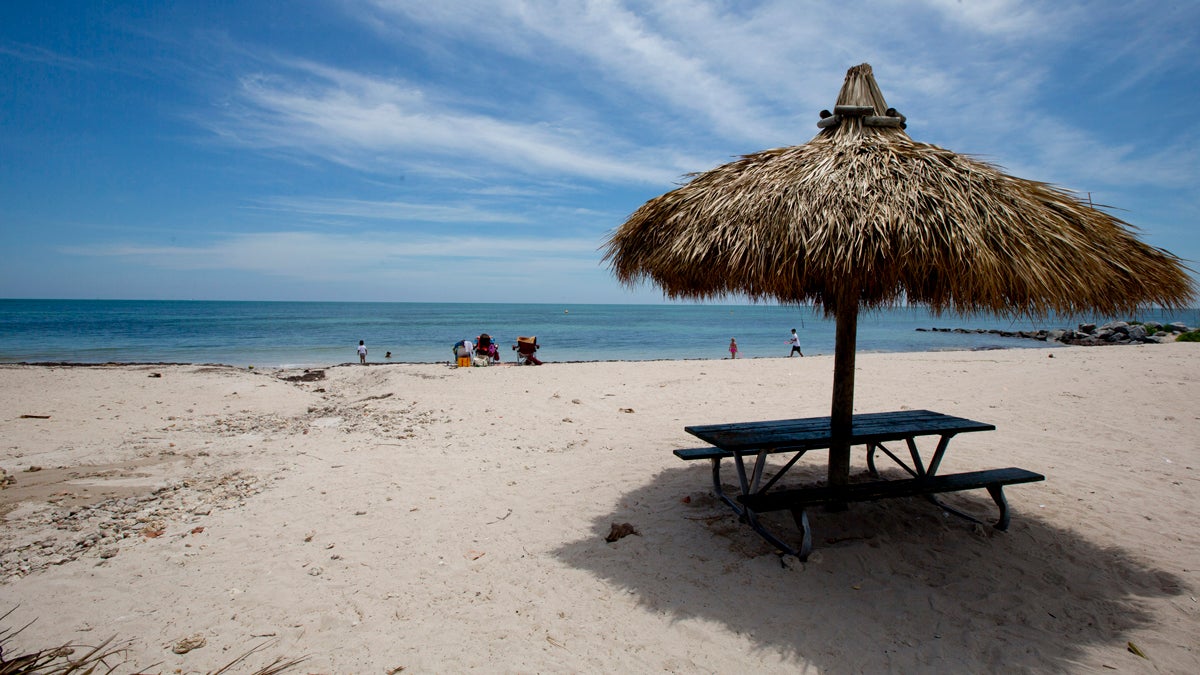  In this April 21, 2014 photo, people walk along one of the beaches in Key Biscayne, Fla. While there is a wide open beach now, many officials fear that in years to come, rising sea levels may destroy the open area. (J. Pat Carter/AP Photo) 