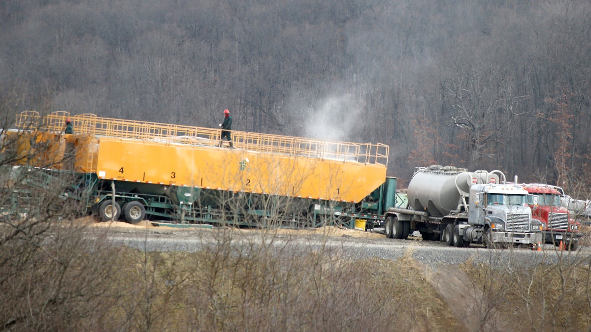  A worker walks on top of a container of chemicals used in the making of a brine water that is then pumped below the surface in a hydraulic fracturing process to release natural gas from shale deposits at a gas well site in Zelienople, Pa. A new fee on gas drilling has generated millions of dollars more in revenue than first projected, but other major gas-producing states tax the industry at higher rates. (Keith Srakocic/AP Photo, file) 