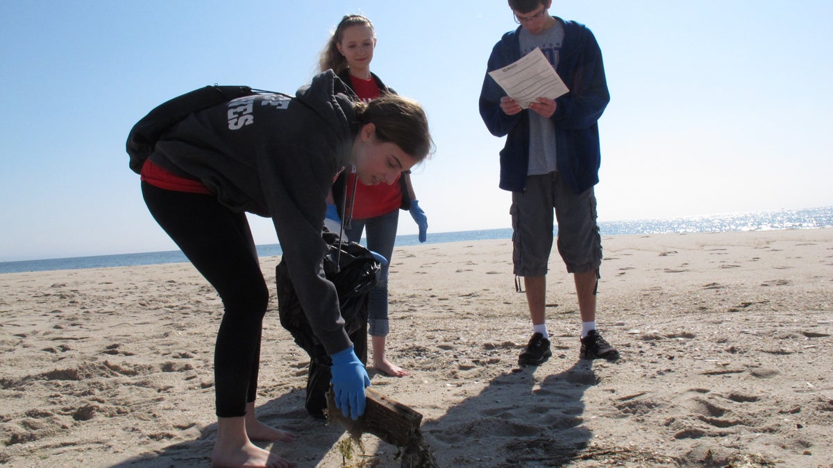 In this April 2012 photo, three teens participate in beach sweeps sponsored by the Clean Ocean Action environmental group, removing thousands of items that were either left behind by beachgoers, or that washed up with the tides after being discarded elsewhere. (Wayne Parry/AP Photo, file) 
