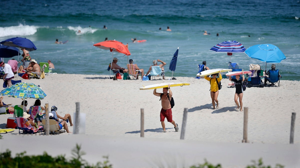  Surfers carry their surfboards across the beach as they call it a day, late in the afternoon, in Long Beach Township, N.J. (Mel Evans/AP Photo) 
