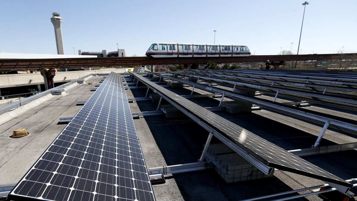 Solar panels that were recently placed on the roof of the building supplying energy to the AirTrain at Newark Liberty International Airport are seen as the train rolls by, Thursday, April 24, 2014, in Newark, N.J. According to The Port Authority of NY and NJ, the 3,200-solar panel installation spread among four building rooftops will supply the airport with 0.7 MW, equivalent to powering 61 homes with electricity, conserving 992 barrels of oil or removing 90 passenger vehicles from the road each year. (AP Photo/Julio Cortez)