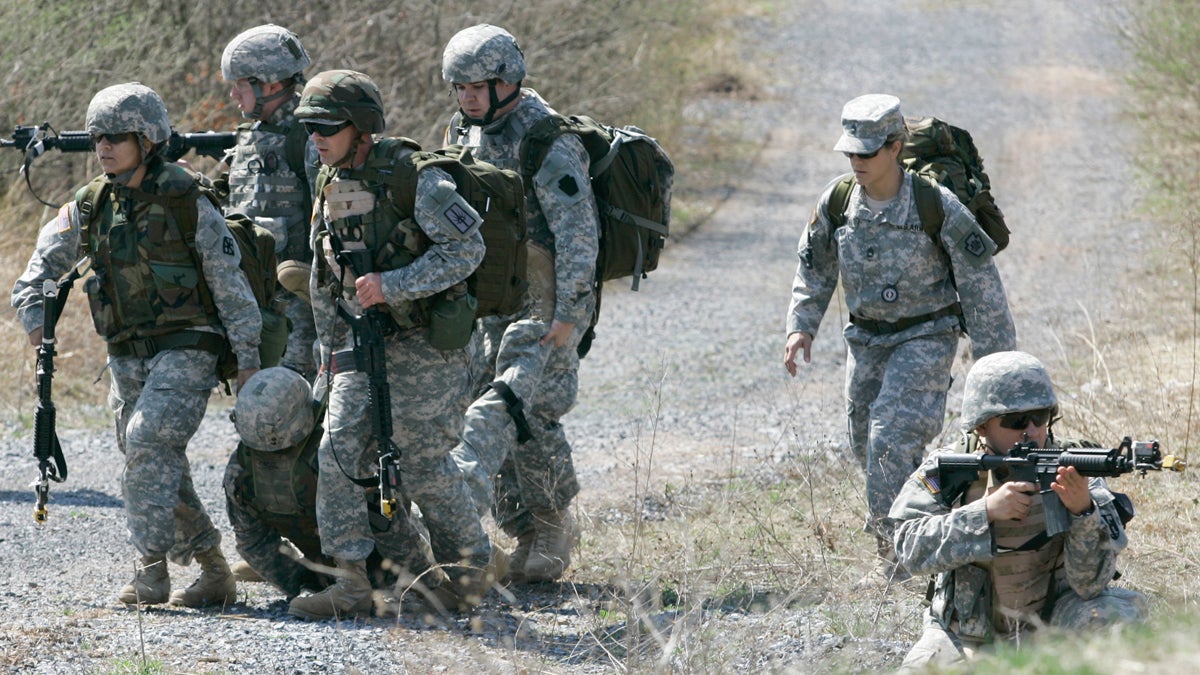  A member of the Pennsylvania National Guard takes up a security position while others remove an injured man during a battle simulation exercise at Fort Indiantown Gap in Annville, Pa. (Carolyn Kaster/AP Photo, file) 