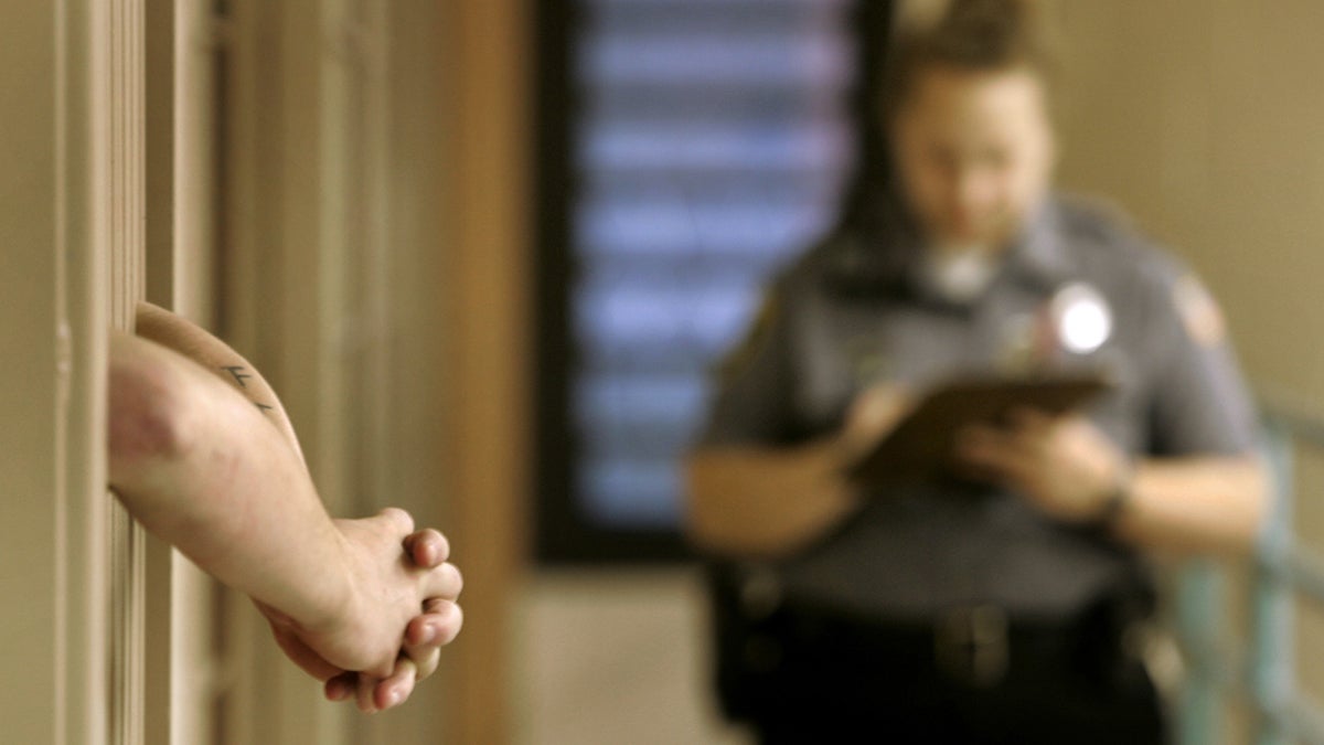  An inmate rests his arms outside his cell as a corrections officer does a cell check. (Carolyn Kaster/AP Photo, file) 