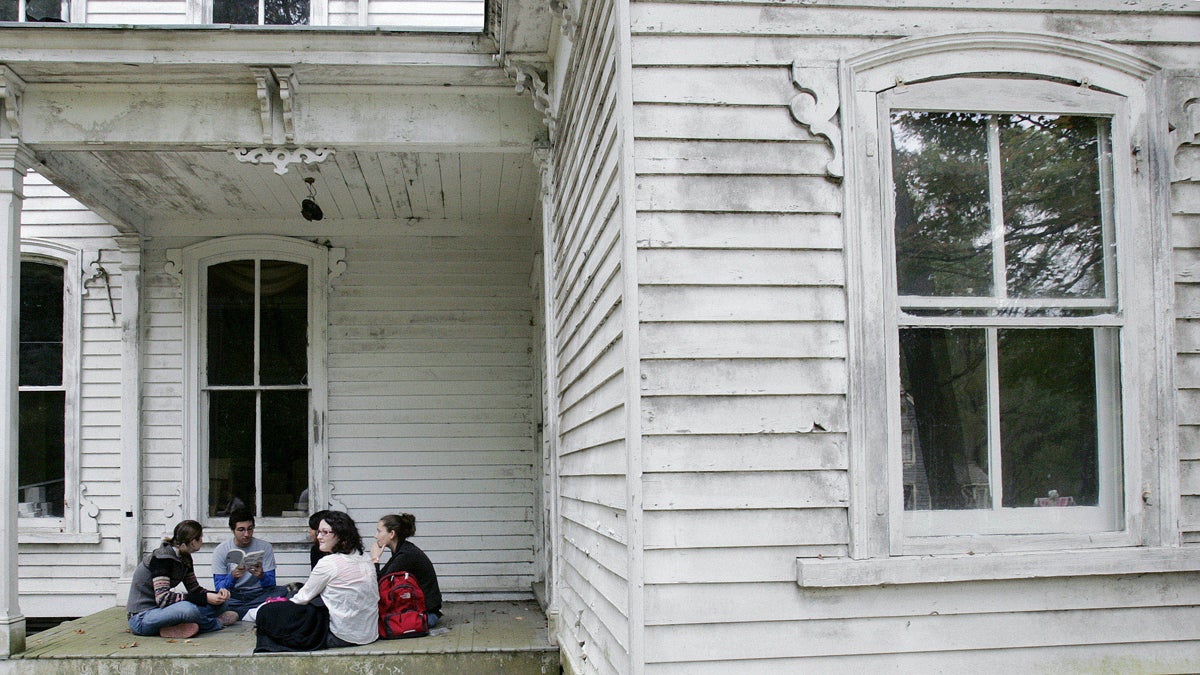  A group of high school students read poetry as they sit on the porch of an old home. (Mel Evans/AP Photo)  