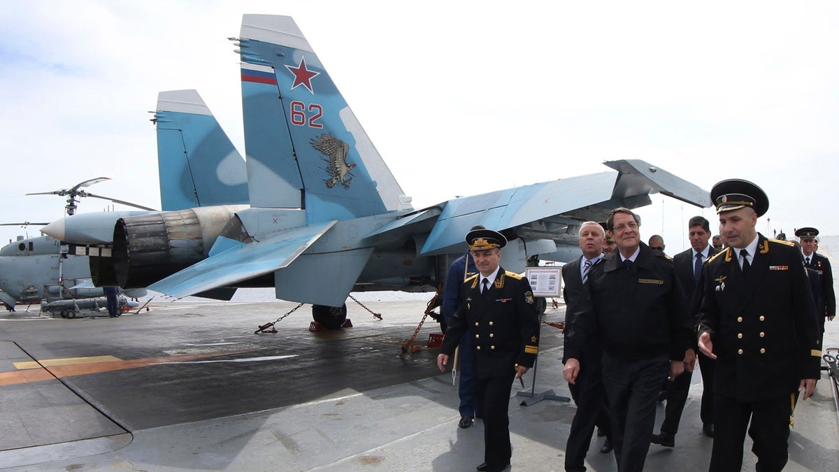  In this handout photo released from Cyprus Information Office, President of Cyprus Nicos Anastasiades, front second from right, walks with members of the Russian aircraft carrier “Admiral Kuznetsov” during his tour of the vessel outside of Limassol port south of Cyprus, Friday, Feb. 28, 2014. Anastasiades said Cyprus can act as a stabilizing factor in a tumultuous region because it’s uniquely positioned to offer its facilities to warships that engaged in enhancing regional peace and security. The aircraft carrier arrived in Cyprus Thursday for a three-day rest and resupply stay. (AP Photo/Press and Information Office) 
