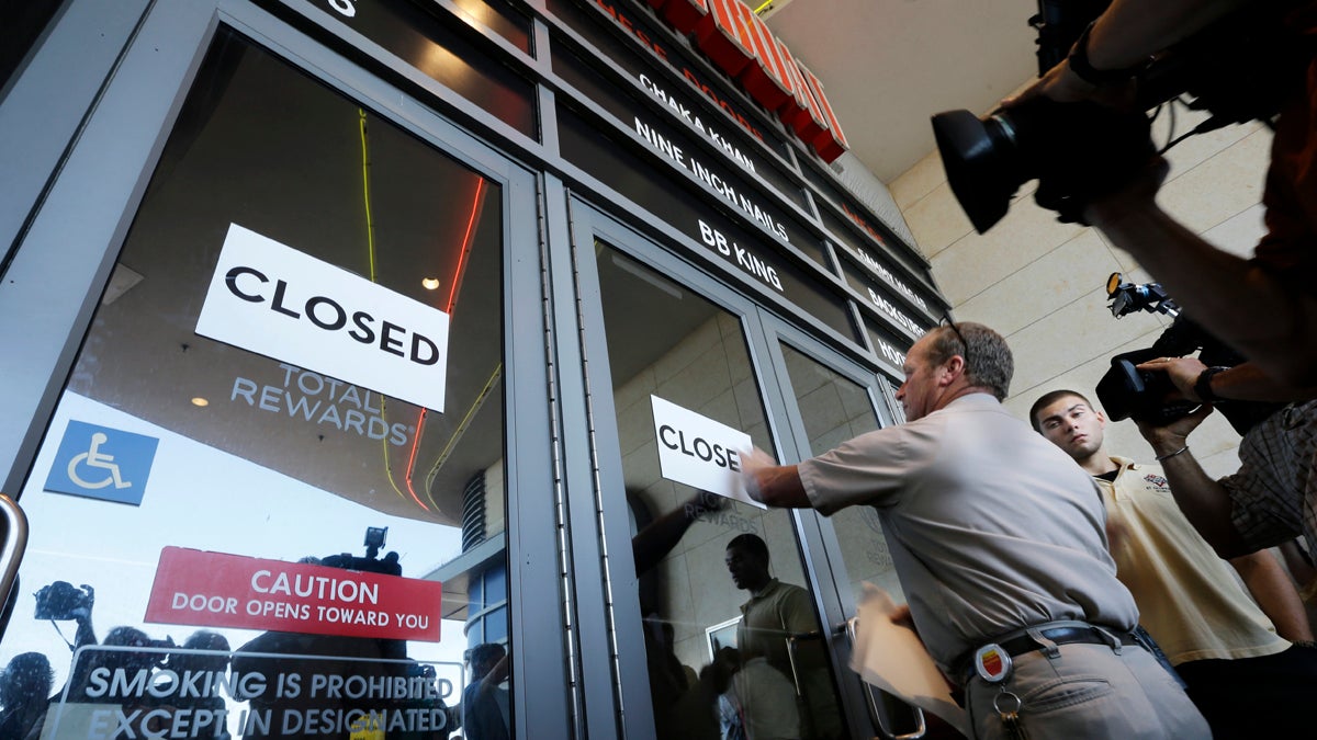  Workers put closed signs on the entrance of the Showboat Casino Hotel, Sunday, Aug. 31, 2014, in Atlantic City, N.J. The show is ending for the Showboat Casino Hotel in Atlantic City. The Mardi Gras-themed casino shut down Sunday after 27 years on the Boardwalk. (Mel Evans/AP Photo) 