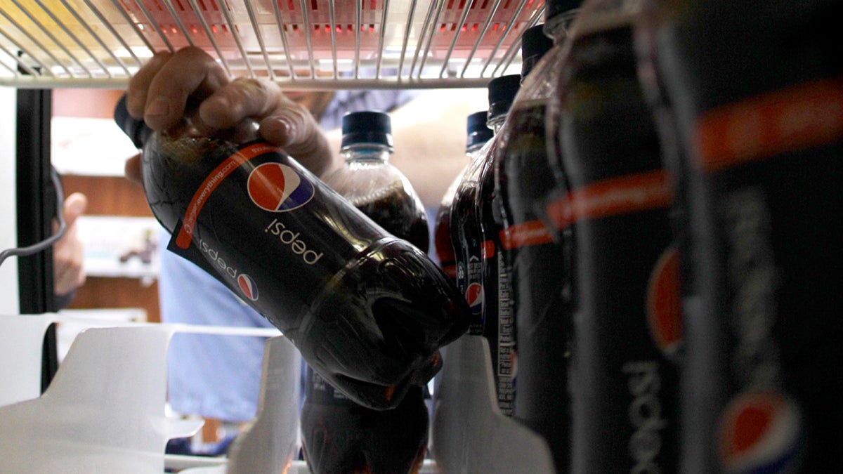 A worker stocks a cooler with soda. (AP Photo/Ted S. Warren