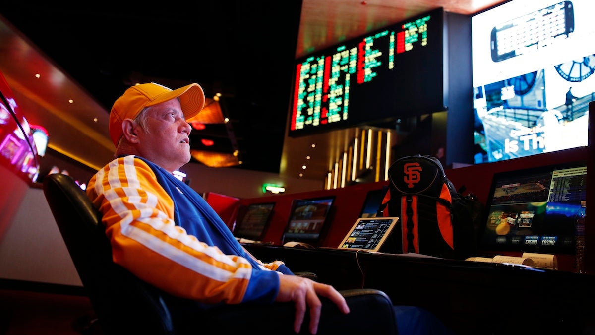  In this Jan. 14, 2015, photo, Amado Nanalang watches basketball games while making bets at a sports book owned and operated by CG Technology in Las Vegas. CG Technology owns and operates sports books in Las Vegas and is asking the Nevada Gaming Control Board to allow more sports, such as the Olympics, to be wagered upon. (John Locher/AP Photo) 