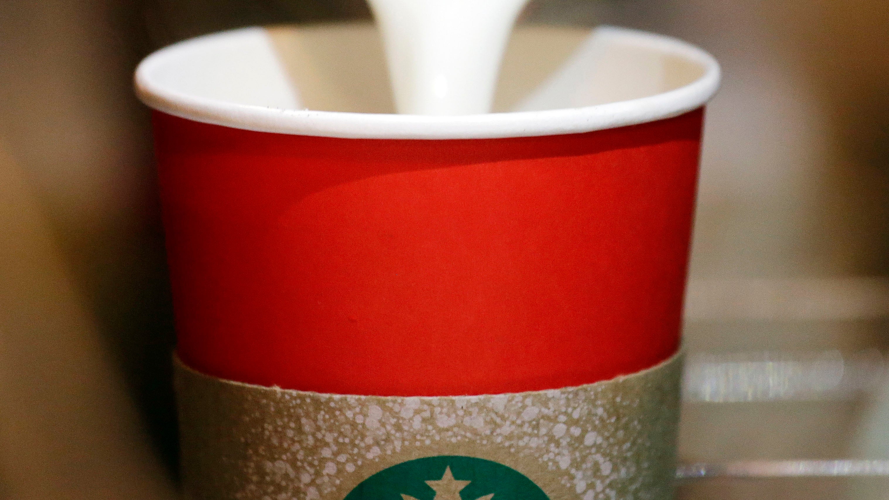  In this Tuesday, Nov. 10, 2015 file photo, a barista pours steamed milk into a red paper cup while making an espresso drink at a Starbucks coffee shop in the Pike Place Market in Seattle. An evangelist's Facebook diatribe criticizing Starbucks for supposedly taking Christ out of Christmas by designing cups without seasonal symbols has garnered millions of views in early November 2012. But few of the those known for longstanding concerns about a so-called 'War on Christmas' are joining his complaint. Others wonder how this controversy, if indeed it is one, fits into the long history of squabbles over the place of Christmas in the public square. (Elaine Thompson/AP Photo) 