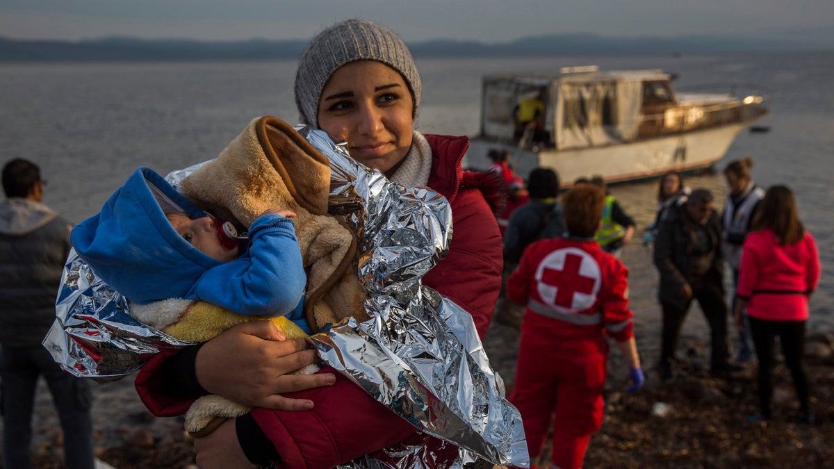 A Syrian woman holds her baby after their arrival on a small boat from the Turkish coast on the northeastern Greek island of Lesbos Monday