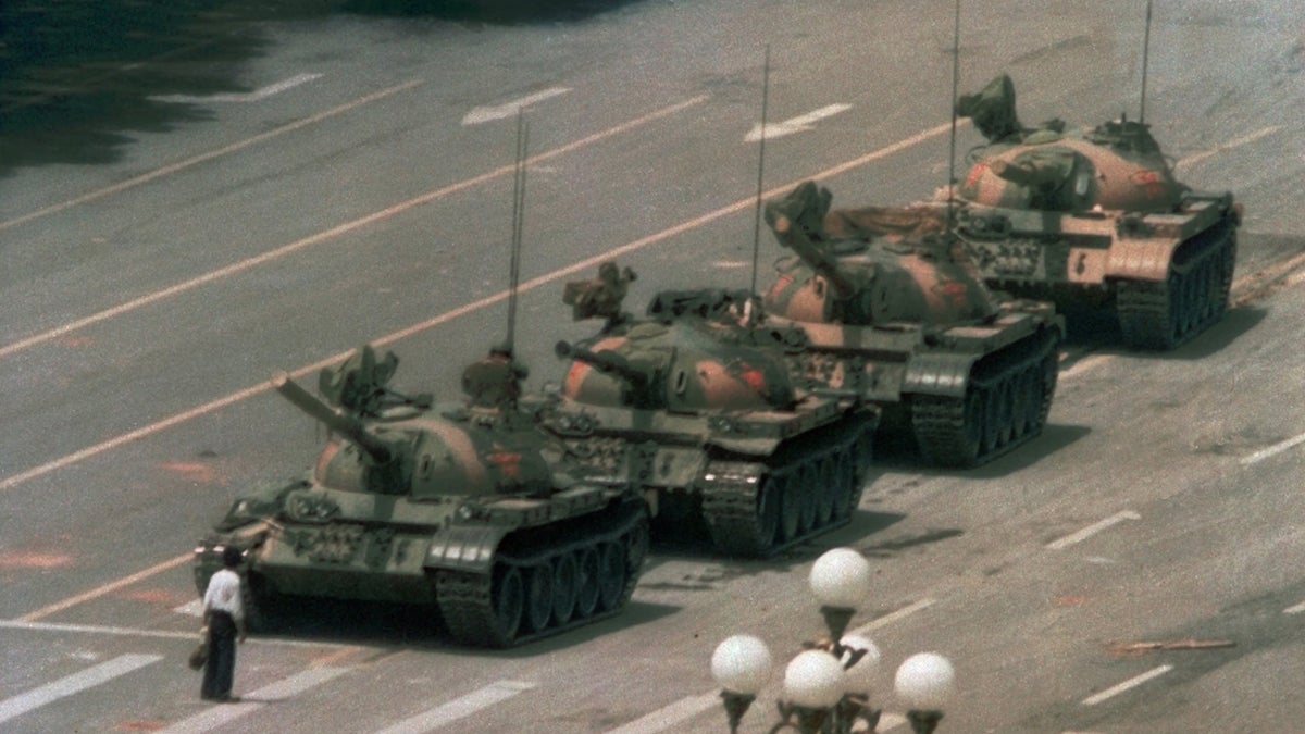  A Chinese man stands alone to block a line of tanks heading east on Beijing's Cangan Blvd. in Tiananmen Square on June 5, 1989.  The man, calling for an end to the recent violence and bloodshed against pro-democracy demonstrators, was pulled away by bystanders, and the tanks continued on their way. (Jeff Widener/AP Photo) 